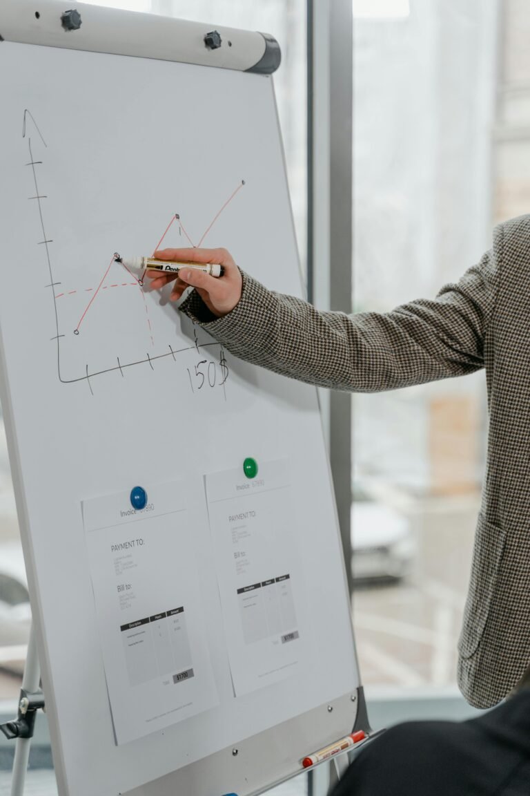 Close-up of a business professional presenting data with a graph on a whiteboard indoors.